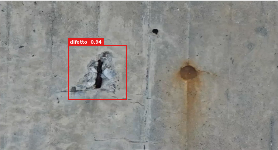 Riquadro rosso attorno a un distacco di copriferro su una parete in calcestruzzo